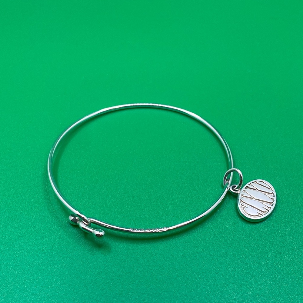 Tiffany & Co. hook and eye bangle with charm.